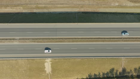 Draufsicht-Auf-Eine-Autobahn,-Auf-Der-Zwei-Autos-Zu-Sehen-Sind,-Die-In-Die-Gleiche-Richtung-Fahren,-Getrennt-Durch-Einen-Abstand