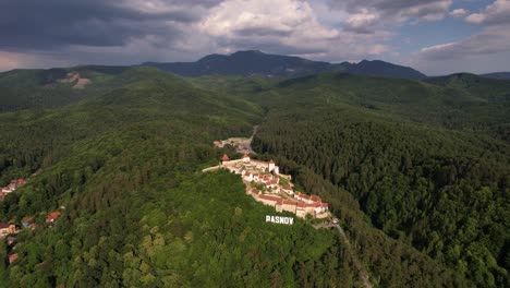 Rasnov-citadel-surrounded-by-dense-forests-in-daylight,-aerial-view