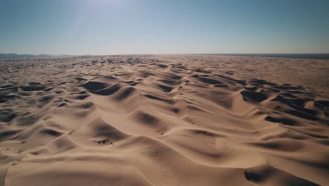 A-drone-ascending-over-Glamis-Sand-Dunes-desert-at-sunrise