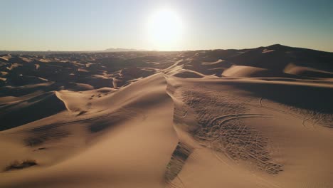 Aerial-drone-shot-in-the-Glamis-Sand-Dunes-desert-after-sunrise,-golden-hour