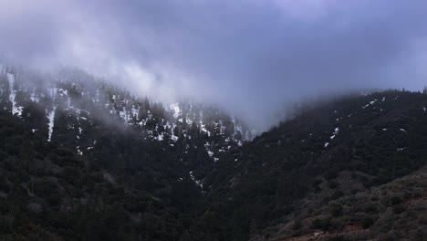 Espectacular-Cobertura-De-Nubes-Moviéndose-Rápidamente-Sobre-Las-Montañas-Cubiertas-De-Nieve-Del-Bosque-De-Pinos-Del-Parque-Frazier-Del-Sur-De-California-60-Fps