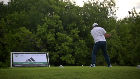 Slow-motion-shot-of-a-latin-mexican-golfer-player-driving-swinging-at-the-teeing-ground-of-a-par-5-hole-on-a-small-tournament