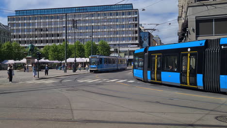 Traffic-in-Central-Oslo-Norway,-Taxi-and-Trams-at-Intersection-on-Sunny-Summer-Day