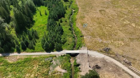 Drone-shot-of-a-small-manmade-bridge-crossing-Breakfast-Creek-in-Spirit-Lake,-Idaho