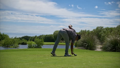 Zeitlupe-Eines-Lateinamerikanischen-Golfers-In-Grauem-Adidas-Outfit,-Der-Seinen-Abschlag-Und-Ball-Für-Den-Drive-Verlegt