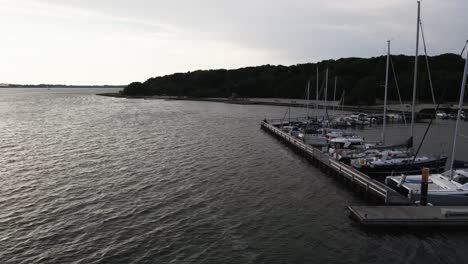 Luftaufnahme:-Flug-Neben-Einem-Kleinen-Hafen-Mit-Fischerbooten-In-Den-Sonnenuntergang