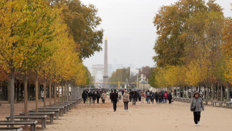 People-Walking-At-The-Grande-Allee-Of-Tuileries-Garden-With-Place-De-La-Concorde-And-Arc-De-Triomphe-In-Autumn-In-Paris,-France