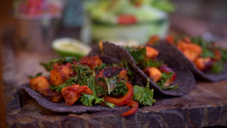 Zeitlupen-Schwenkaufnahme-Von-Gegrillten-Oktopus-Tacos,-Mariniert-Mit-Traditionellem-Mexikanischen-Adobo,-Serviert-Mit-Salat-Auf-Blauen-Maistortillas