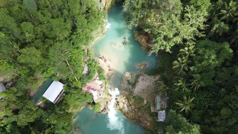 Aqua-blue-plunge-pools-of-kawasan-waterfall-in-lush-nature,-Aerial-top-down