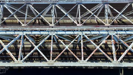 Eine-Eisenbahnbrücke-Mit-Viel-Metallkonstruktion,-Fluss-Im-Hintergrund
