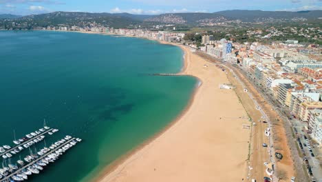 En-Lo-Alto,-Palamós-Revela-Su-Dinámico-Paseo-Marítimo-Bordeado-De-Palmeras,-Que-Invita-A-Pasear-Tranquilamente-Por-La-Costa.