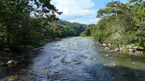 Langsamer-Drohnenflug-über-Einen-Natürlichen-Fluss-Mit-Felsen-Und-Bäumen-In-Der-Dominikanischen-Republik,-Rio-Yaque-Del-Norte