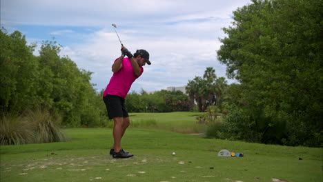 Zeitlupe-Eines-Lateinamerikanischen-Mexikanischen-Golfers-Mit-Einem-Rosa-Hemd,-Der-Einen-Fürchterlichen-Schlag-Macht-Und-Den-Ball-In-Die-Bäume-Schickt