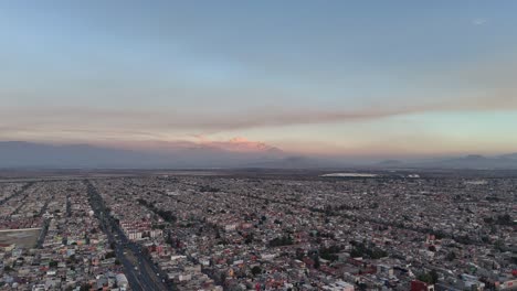 Aerial-view-of-the-Ecatepec-area,-with-the-volcanoes-in-the-background,-Mexico-City