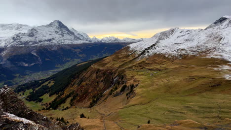 First-Cliff-metal-walk-way-Grindelwald-Switzerland-Swiss-Alps-snowy-Jungfrau-Junfrangu-glacier-Lauterbrunnen-mountain-peaks-October-cloudy-autumn-evening-landscape-sunset-waterfalls-valley-pan-left