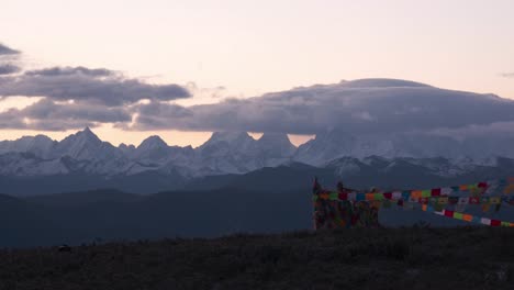 Prayer-Flags-And-Cloud-capped-Mount-Gongga-At-Sunrise-In-Yuzixi,-Sichuan,-China