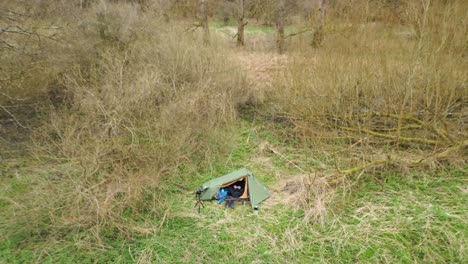 Hombre-Sentado-Dentro-De-Una-Tienda-De-Campaña,-Volando-Un-Dron-En-El-Bosque-De-Thetford-En-Norfolk,-Reino-Unido