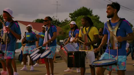 Einheimische-Aus-Der-Karibik-Tanzen-Und-Schlagen-Während-Des-Karnevalsumzugs-Bei-Sonnenuntergang-Auf-Trommeln