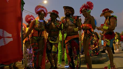 Men-and-woman-with-shiny-body-paint-in-elegant-Carnival-costumes-party-holding-alcohol-at-dusk