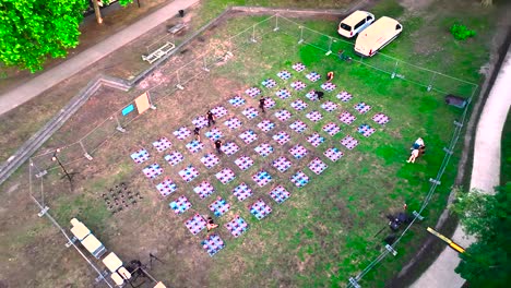 Array-of-drones-being-prepared-for-nighttime-display-at-Wine-Fair,-Aerial-looking-down-shot