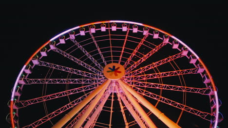 Closeup-of-Colorful-Spinning-Ferris-Wheel-against-Night-Sky