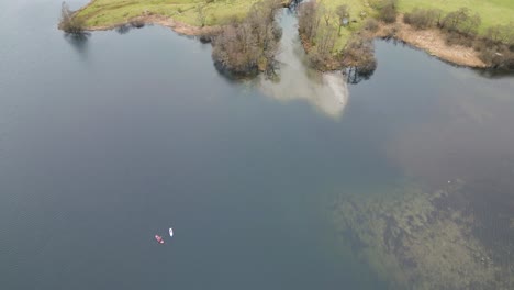 Aerial-View-Of-Canoe-Boats-In-Tranquil-Lake-Near-Grasmere-Village-In-Cumbria,-England