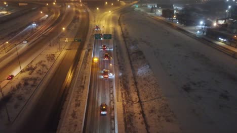 aerial-following-emergency-snow-removal-team-at-night-as-all-lanes-are-cleared-as-a-team