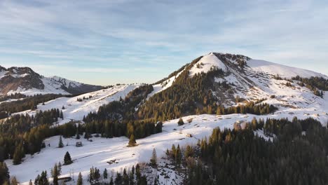 Sunlit-Amden-slopes-under-clear-blue-skies,-Switzerland---aerial