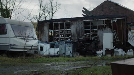 Abandoned-house-with-caravan-and-trash-outside