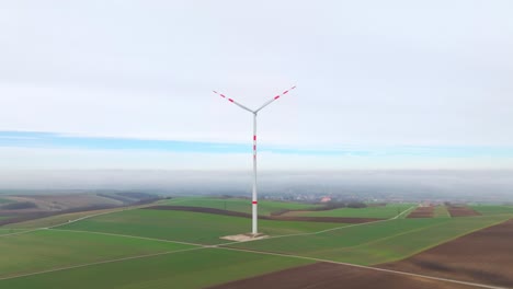 Windkraftwerk---Rotierende-Windturbine-Mit-Nebligem-Hintergrund