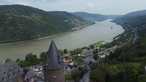 Medieval-Stahleck-Castle-atop-Scenic-Towns-of-Rhine-Valley,-Aerial