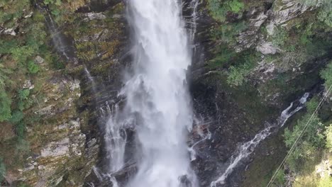 Panorámica-Aérea-Desde-El-Lado-De-Una-Alta-Cascada-Alojada-En-Las-Montañas.