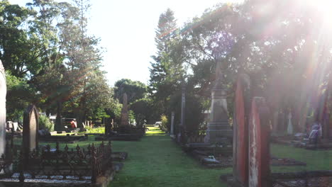 Drone-flying-low-between-gravestones-and-tombs-in-a-cemetery-on-a-sunny-day-in-Australia