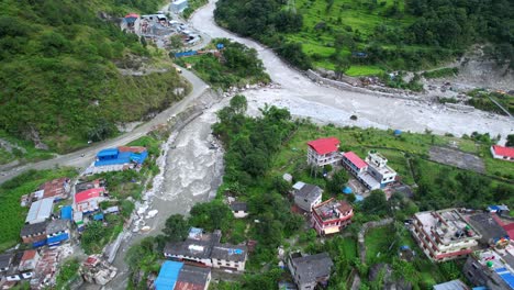 Wunderschöne-Luftlandschaft-Des-Gandaki-Flusses-Und-Der-Häuser-Im-Dorf-Marpha-Am-Flussufer,-Drohnenflug-über-Marpha-In-Nepal