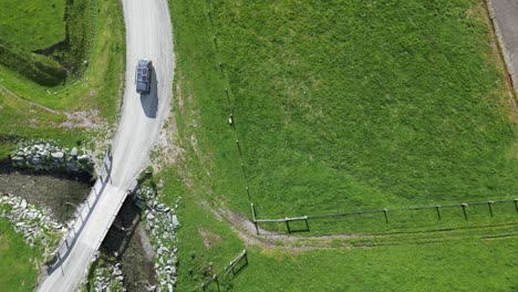 Dunkelblauer-Lieferwagen-Fährt-über-Eine-Brücke-Und-Eine-Schotterstraße