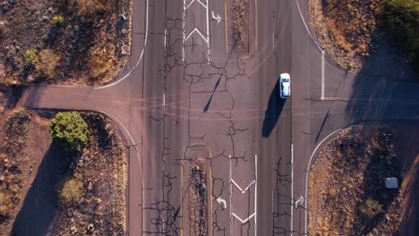 Birds-Eye-Aerial-View-of-Cracked-Asphalt-Road-and-Cars,-Arizona-State-Route,-High-Angle-Drone-Shot
