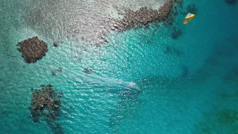 A-kite-surfer-gliding-over-turquoise-waters-at-los-roques,-aerial-view