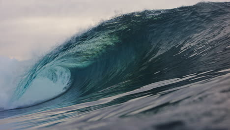 Low-ocean-surface-view-of-green-crystal-clear-wave-barreling-in-slow-motion