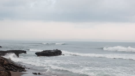 Olas-Fuertes-Rompiendo-En-Las-Rocas-Y-La-Playa-En-Bali,-Indonesia