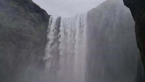 Powerful-Waterfall,-Mist-and-Volcanic-Cliffs-of-Iceland