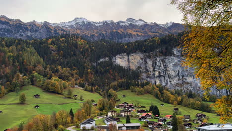 Staubbach-Falls-Lauterbrunnen-Switzerland-Swiss-alpine-valley-village-Jungfrangu-Grindelwalk-Interlaken-Bernese-Alps-sunset-golden-hour-autumn-October-fall-colors-glacier-gigantic-rock-face-pan-left