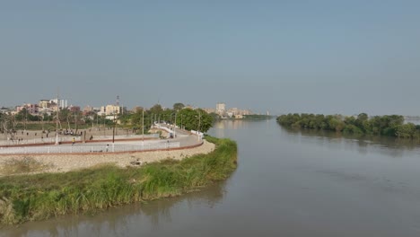 Drone-flies-backwards-from-a-promenade-over-the-indus-river-Sukkur