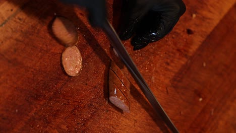 Chef-Cutting-Pork-Sausage-With-Sharp-Kitchen-Knife