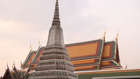 buddhist-spire-in-front-of-orange-roof-of-a-temple-in-the-Rattanakosin-old-town-of-Bangkok,-Thailand