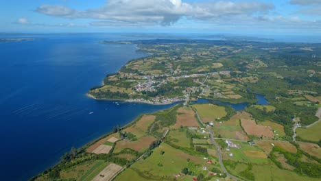 Panoramic-aerial-view-establishing-Lemuy-Island,-green-meadows-and-rural-environment
