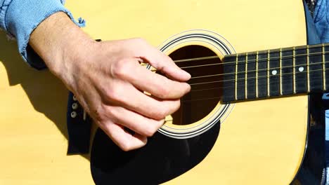 Closeup-static-video-of-a-man-finger-picking-on-a-guitar