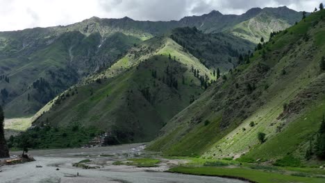 Un-Dron-Se-Desplaza-Para-Enmarcar-Una-Balsa-Que-Flota-En-Las-Aguas-De-Naran-Frente-A-Un-Espectacular-Paisaje-Montañoso,-Combinando-La-Aventura-Con-La-Naturaleza.