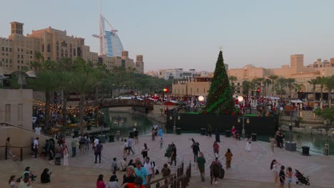 Dubai,-Emiratos-Árabes-Unidos---26-De-Diciembre-De-2023:-Turistas-Disfrutando-De-Su-Tiempo-Alrededor-De-Un-árbol-De-Navidad-En-El-Zoco-Madinat-Jumeirah-En-Dubai.