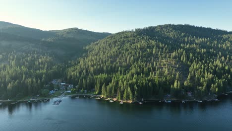 Drone-shot-of-Spirit-Lake,-Idaho-with-sun-kissing-the-tree-tops
