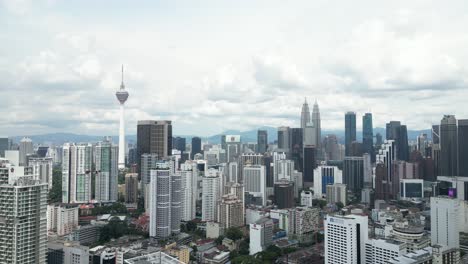 aerial-drone-shot-of-KL-Tower-and-Petronas-Twin-Towers-in-Kuala-Lumpur,-Malaysia